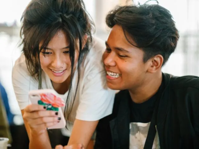 Two students looking at a cellphone screen