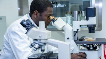 Scientist looking through microscope